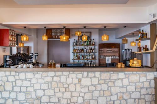 a bar in a restaurant with lights above the counter at SOPHID Wellness Suites Karpathos in Karpathos Town
