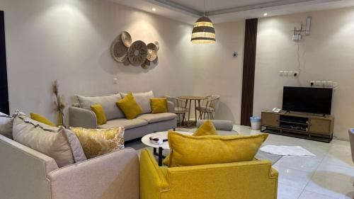 a living room with a couch and a tv at نوليتا للشقق الفندقية in Abha
