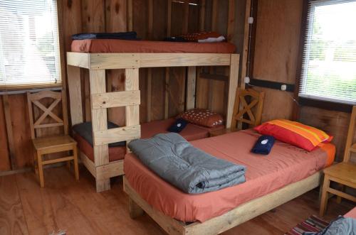 a bedroom with two bunk beds in a cabin at La Brújula Hostel in La Paloma