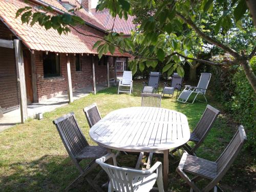 a white table and chairs in a yard at Gîte rural Les petites têtes in Leuze-en-Hainaut