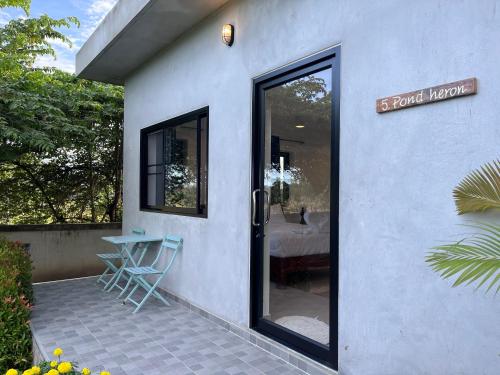 a front door of a house with a table and chairs at Little Bird in Prachuap Khiri Khan