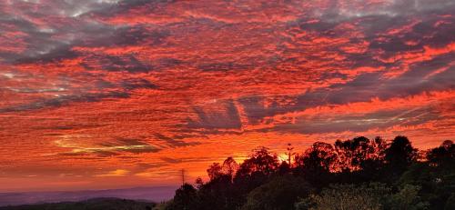 a sunset with red clouds in the sky at Maleny Views Motel in Maleny