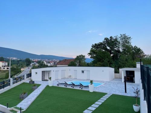a large backyard with a pool and grass at Casa La Familia in Posušje