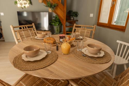 a wooden table with plates and cups on it at Triplex Jungle Family in Sorgues