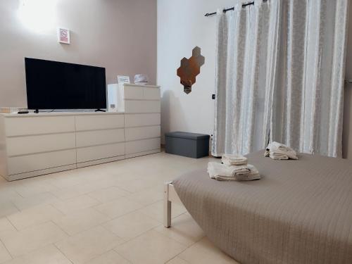 a bedroom with a bed and a flat screen tv at Appartamento Sofia in zona residenziale strategica wifi gratuito in Carbonara al Ticino