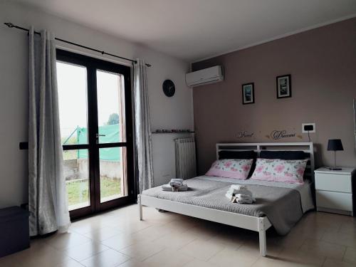 a bedroom with a bed and a large window at Appartamento Sofia in zona residenziale strategica wifi gratuito in Carbonara al Ticino