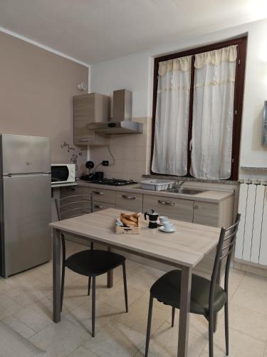 a kitchen with a table and chairs and a refrigerator at Appartamento Sofia in zona residenziale strategica wifi gratuito in Carbonara al Ticino