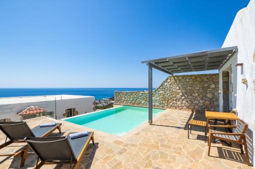 a villa with a swimming pool and the ocean at SOPHID Wellness Suites Karpathos in Karpathos Town