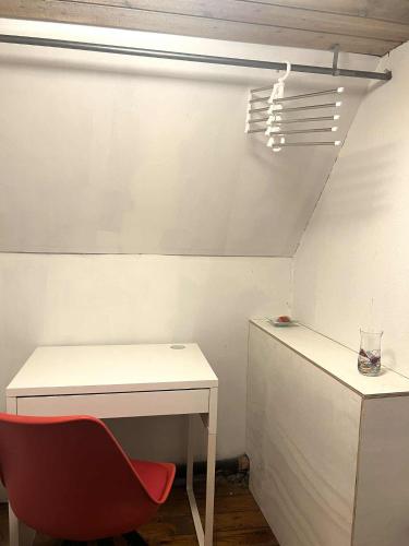 a red chair sitting next to a white desk at Gravsgade 55 in Ribe