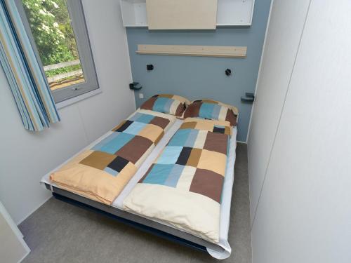 a bed in a room with a window at Mobile Home in Sachsenburg by River Drau in Sachsenburg