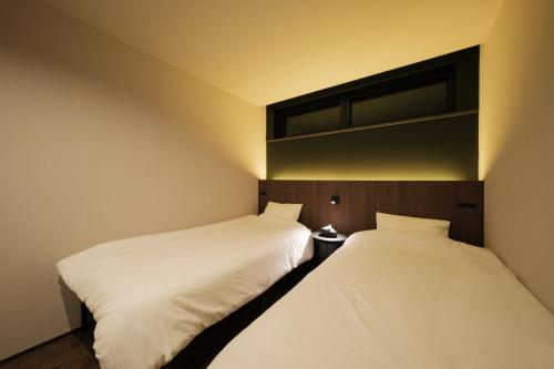 two beds sitting next to each other in a room at HK House in Ichinomiya