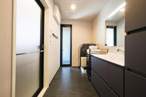 a bathroom with a sink and a mirror at HK House in Ichinomiya