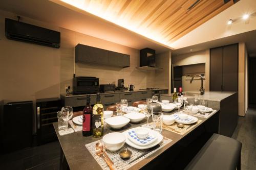 a kitchen with a table with plates and wine glasses at HK House in Ichinomiya