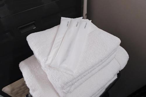 a stack of white towels sitting on a shelf at HK House in Ichinomiya