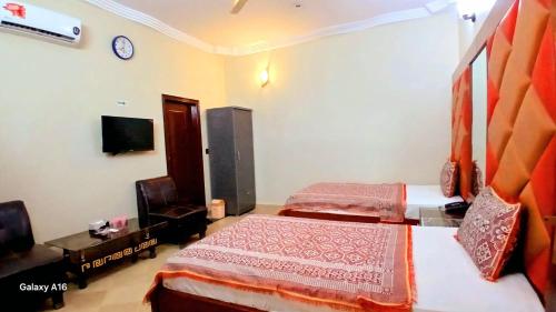 a hotel room with two beds and a tv at GULSHAN PALACE Near AghaKhanHospital ExpoCenter Airport in Karachi
