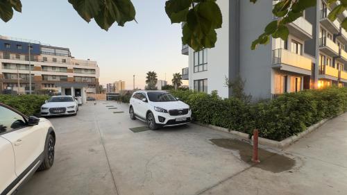 two cars parked in a parking lot next to a building at Ethica Suite Luxury Houses in Aksu