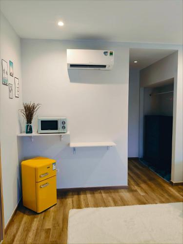 a kitchen with a yellow cabinet and a microwave at SUN House in Phu Quoc