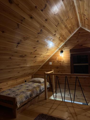 a bedroom with a bed in a wooden cabin at HRID - vikendica u prirodi in Šavnik