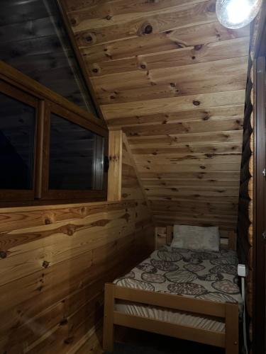 a small room with a bed in a wooden cabin at HRID - vikendica u prirodi in Šavnik