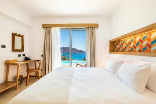 a bedroom with a bed with a view of the ocean at SOPHID Wellness Suites Karpathos in Karpathos Town