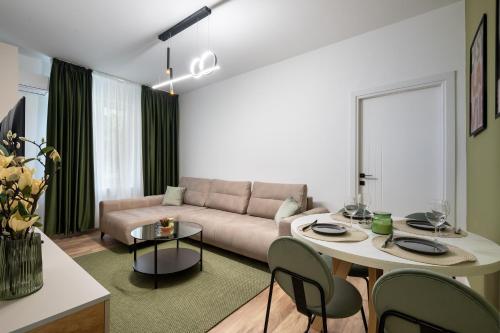 a living room with a couch and a table at Rossini King bed i BR Apartment in Bucharest