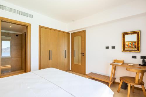 a bedroom with a bed and a wooden desk at SOPHID Wellness Suites Karpathos in Karpathos Town