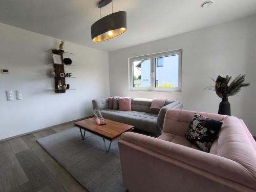 a living room with a couch and a table at VILLA VULKANEIFEL -modern -familienfreundlich -Terrasse -Doppelgarage -ruhiger Lage in Darscheid