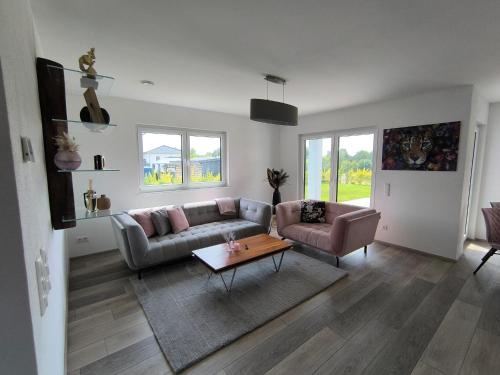 a living room with a couch and a table at VILLA VULKANEIFEL -modern -familienfreundlich -Terrasse -Doppelgarage -ruhiger Lage in Darscheid