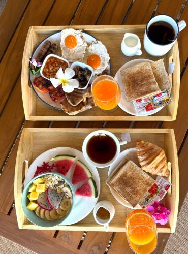a wooden tray with two trays of breakfast food at Erawan Villa Hotel in Bangrak Beach