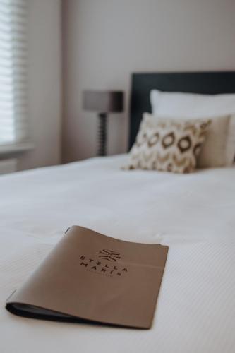 a sign on top of a white bed at Boutique Hotel Stella Maris in Maastricht