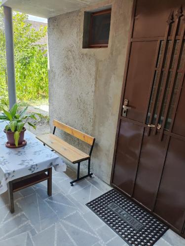 a wooden bench and a table next to a door at Mashtots B&B in Vanadzor