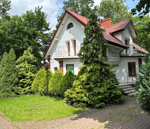 a white house with a red roof at Apartamenty przy uzdrowisku in Inowrocław