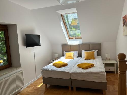 a bedroom with a bed with yellow pillows on it at Apartamenty przy uzdrowisku in Inowrocław