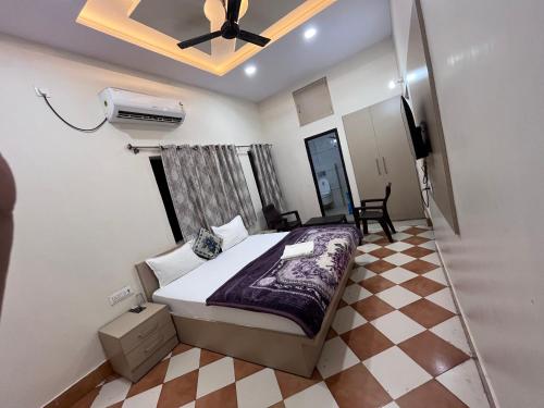 a bedroom with a bed and a ceiling fan at Hotel Shiv Kashi in Varanasi