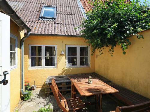 a wooden table and chairs in front of a house at 3 person holiday home in Ærøskøbing in Ærøskøbing