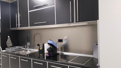 a kitchen with black cabinets and a sink at Lela's home II in Knjazevac.
