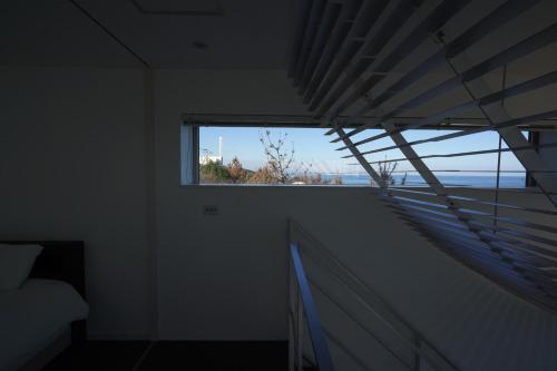a room with a window with a view of the ocean at COCO VILLA 大洗-Sauna- in Oarai