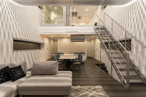 a living room with a couch and a staircase at COCO VILLA 大洗-Sauna- in Oarai