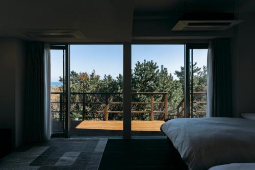 大洗町にあるCOCO VILLA 大洗-Sauna-のベッドルーム1室(ベッド1台付)が備わります。バルコニーの景色を望めます。