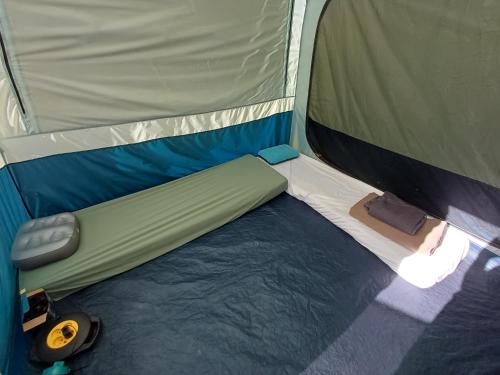 a person laying on a bed in a tent at TENTES sur une aire privée en pleine nature in Massillargues-Attuech