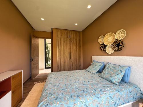 a bedroom with a bed with a blue comforter at Villa Badia, 30 minutes médina, 4 suites, piscine in Oulad Mazoug