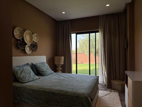 a bedroom with a bed and a large window at Villa Badia, 30 minutes médina, 4 suites, piscine in Oulad Mazoug