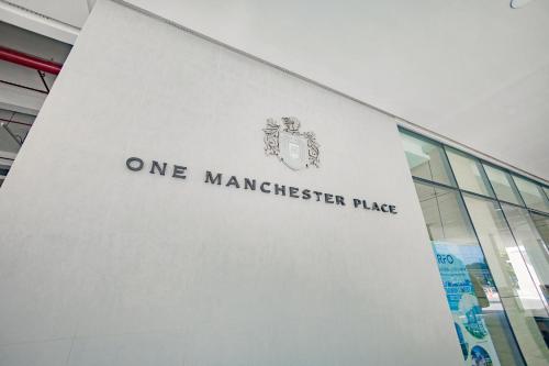 a one manchester place sign on the side of a building at The Mactan Beach Haus in Punta Engaño