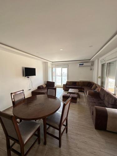 a living room with a table and a couch at T5 spacieux et lumineux in Bir el Djir