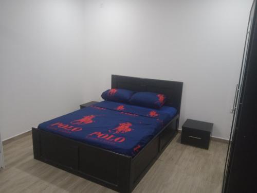a bedroom with a bed with a blue comforter at T5 spacieux et lumineux in Bir el Djir