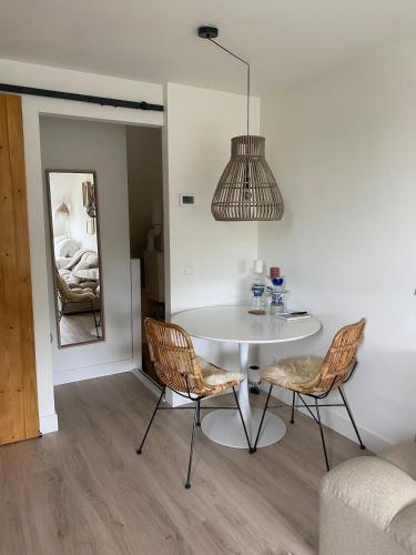 a room with a table and two chairs and a mirror at Appartement Buissant des Amorie! in Castricum