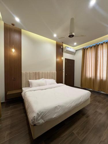 a bedroom with a large bed with white sheets at Munawar Residence in Muzaffarabad