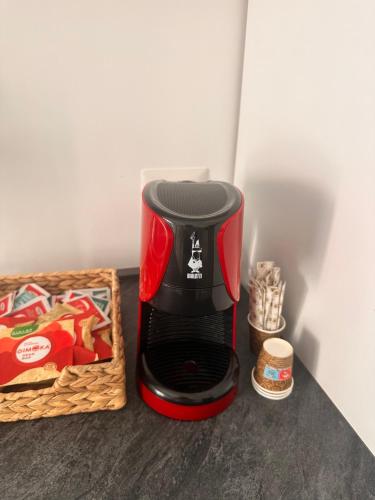 a red and black coffee maker next to a basket at Casa Del Grillo Parlante in Aragona
