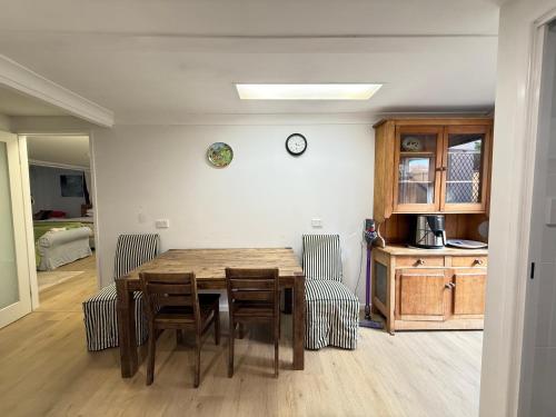 a dining room with a wooden table and chairs at Zen Escape Guest House " Location 1" - Three listings - Romantic Escape, Cozy Delight, Oasis Suite in Brisbane