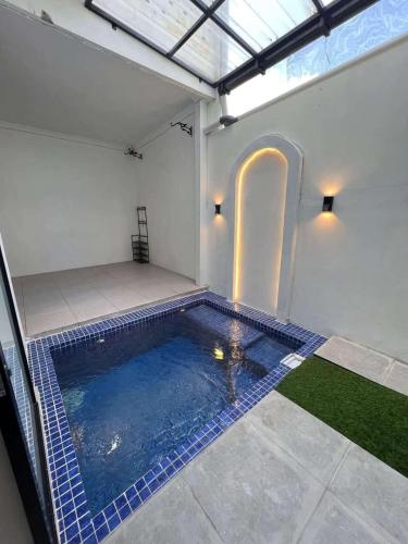 an indoor swimming pool in a building with a room at Kusuma Guest House in Jejeran